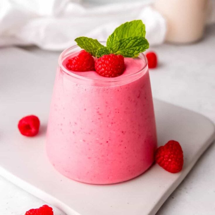 Raspberry smoothie (without banana) topped with raspberries, made after reading these non-alcoholic pink drinks for Valentine's Day