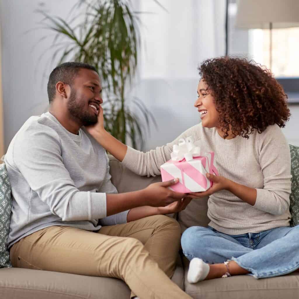 A man giving a gift to his wife after reading these 10 tips for a happy marriage