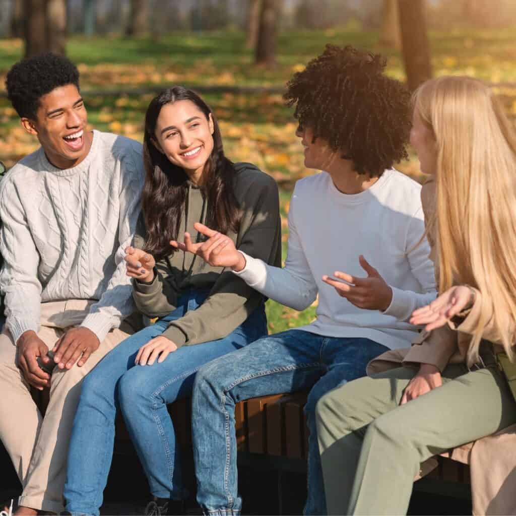 A group of friends in a park asking each other these would you rather questions