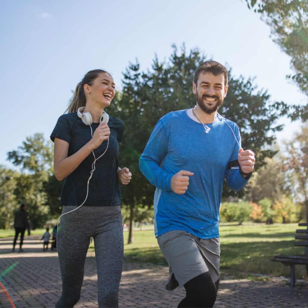 A happy couple jogging at a park together after reading these 10 tips for a happy marriage