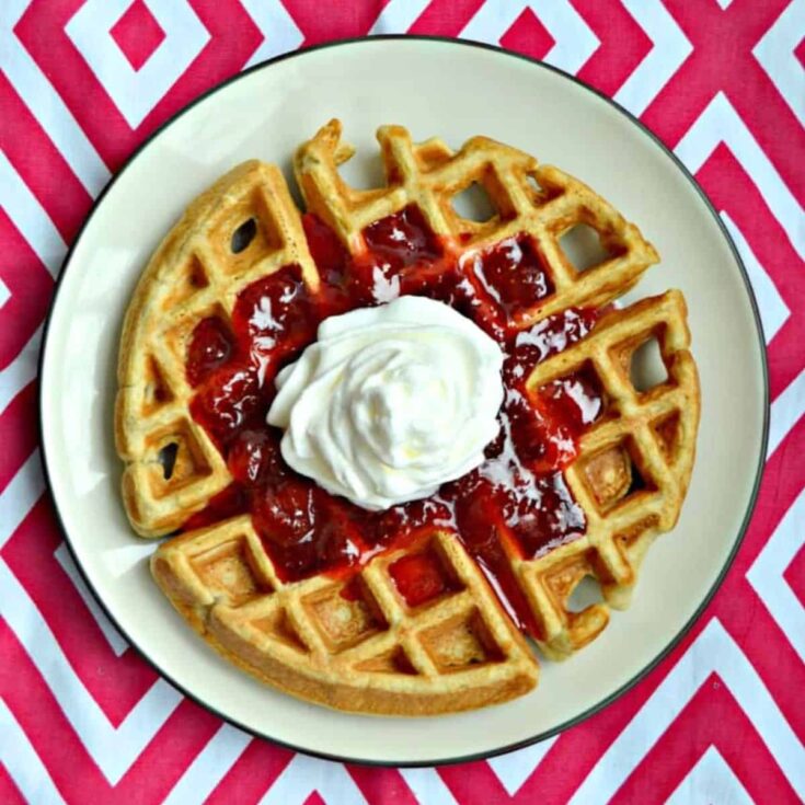 A plate of vanilla bean waffles with strawberry sauce made after reading these Wonderful waffle recipes