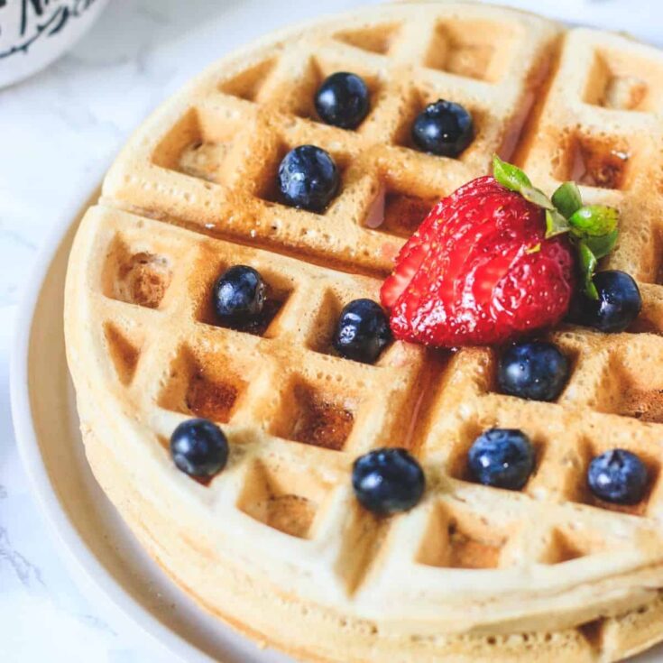 Vegan waffle topped with strawberries and blueberries made after reading these Wonderful waffle recipes