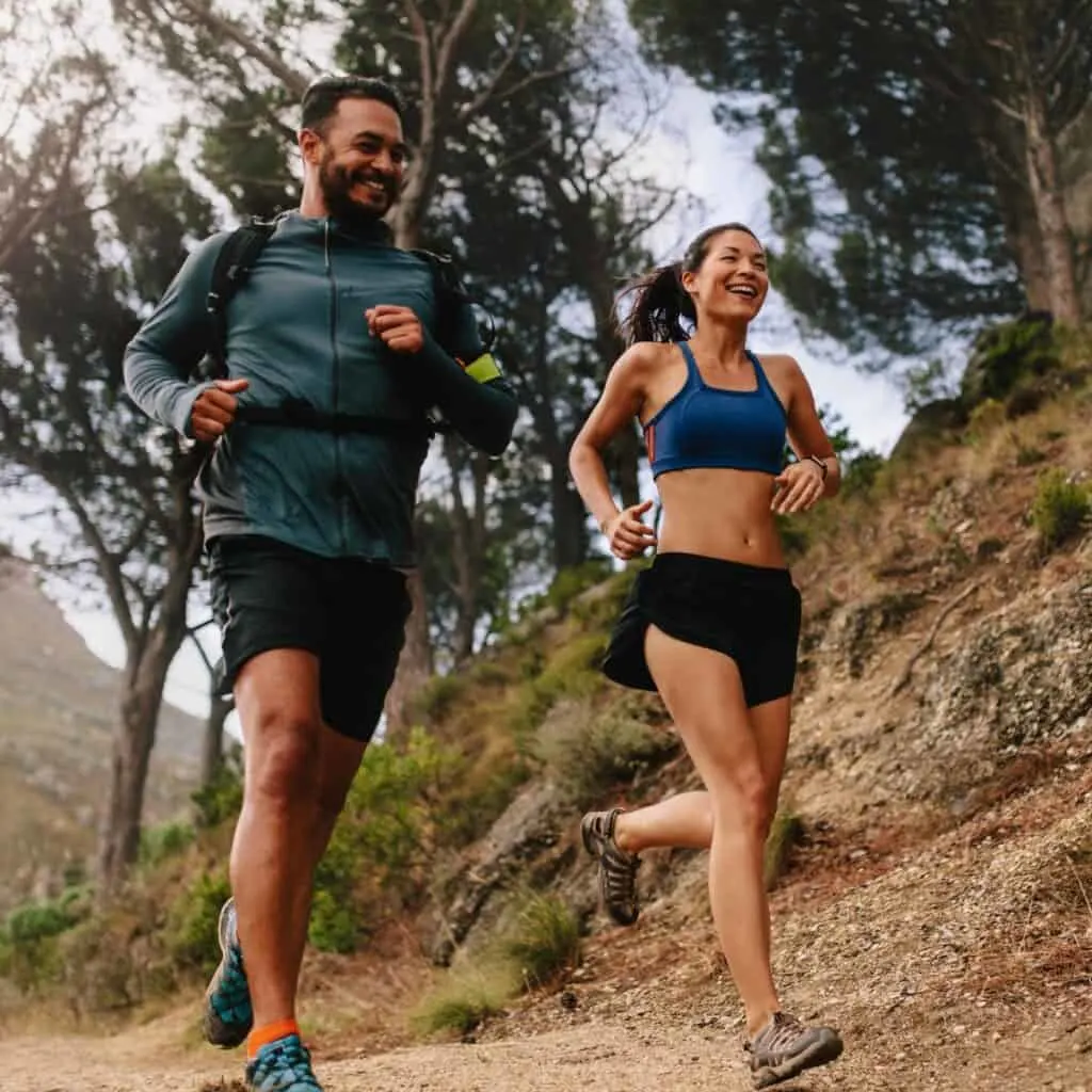 A happy couple running together after reading these active hobbies for couples you can do outdoors