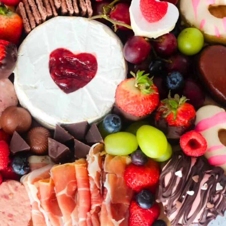 Charcuterie board filled with cheese, ham, chocolates, and more, made after reading these Valentines appetizers
