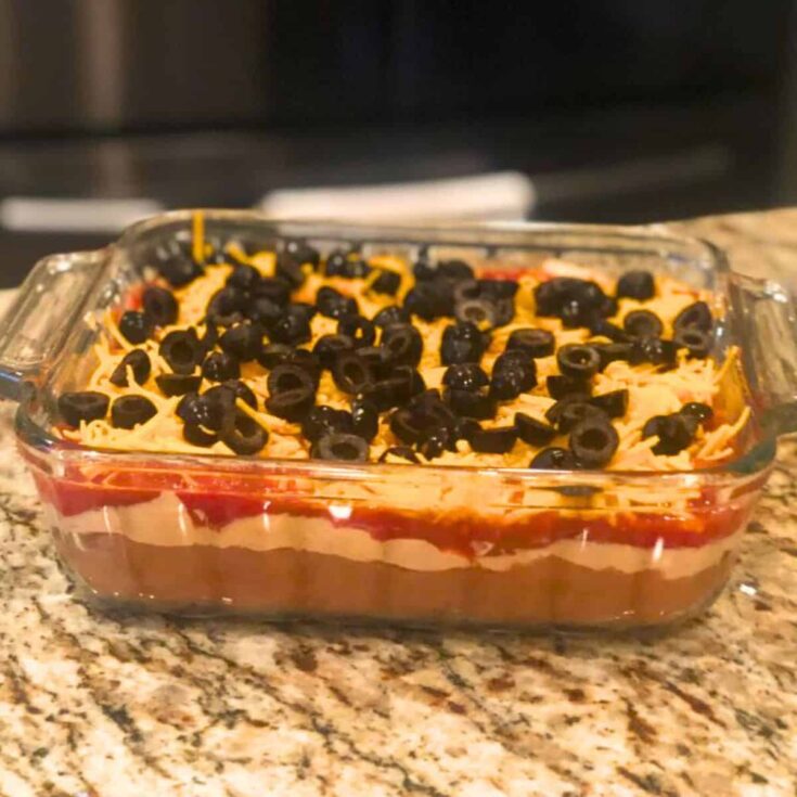 Five layer Mexican dip with salsa made after reading these Mexican appetizers for Cinco de Mayo