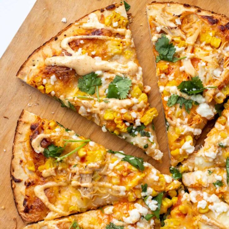 Slices of Mexican chicken flatbread with elote sauce made after reading these Mexican appetizers for Cinco de Mayo