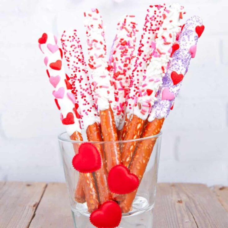 Pretzel rods with white chocolate and sprinkles made after reading these Valentines appetizers
