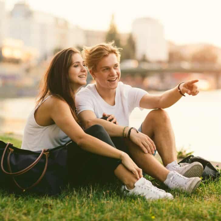 A teen couple at a park looking at a scenery in front of them, after reading these cute date ideas for teens