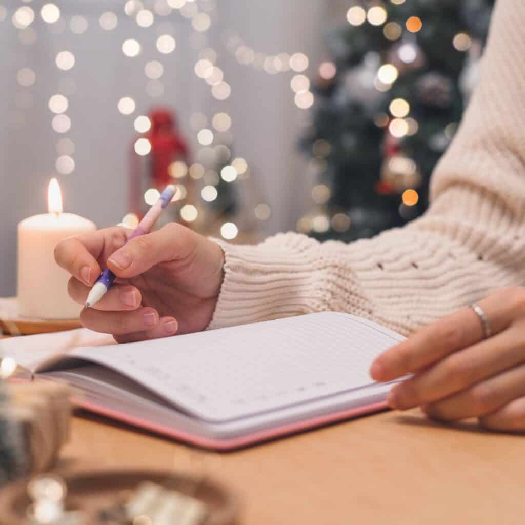 A woman making a Christmas bucket list after reading these Christmas date ideas