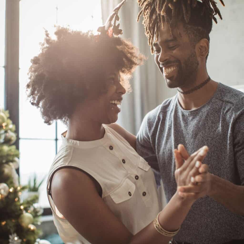 A couple dancing on the playlist they created after reading these Christmas date ideas