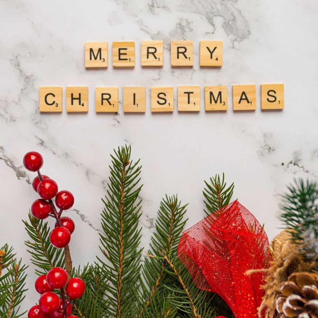 A "Merry Christmas" spelled using scrabble letters with ornaments at the bottom, made after reading these Christmas date ideas