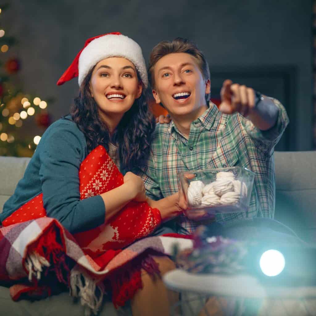 A couple watching a Christmas movie after reading these Christmas date ideas