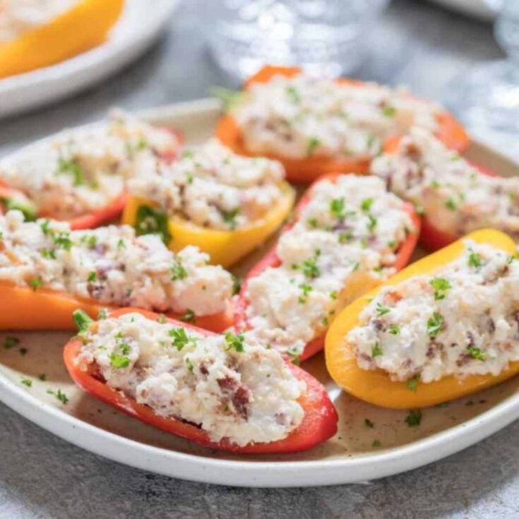 A plate filled with stuffed mini peppers made after reading these New Years Eve appetizers