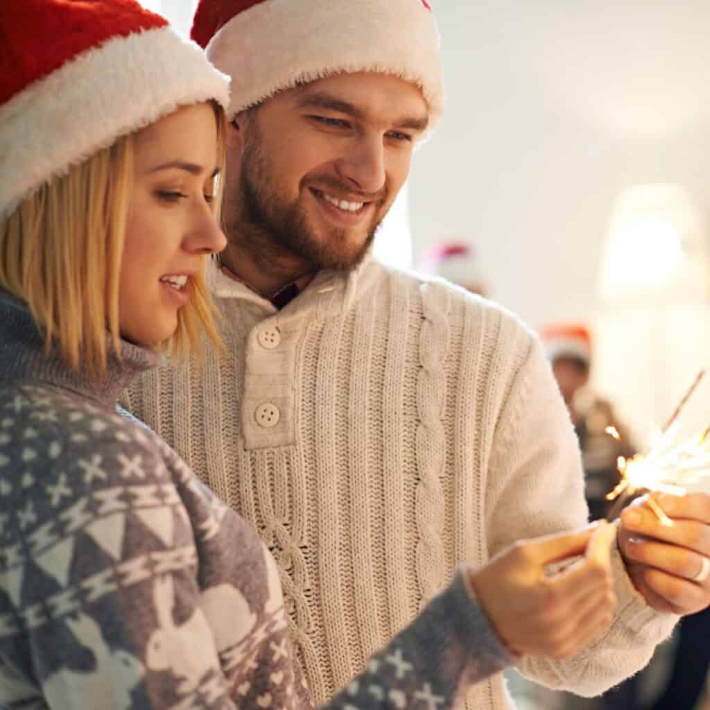 A couple holding a tiny firework: How to survive your family Christmas
