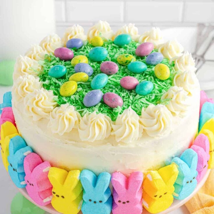 Easter peep cake with multi-colored layers and surrounded with colorful bunnies