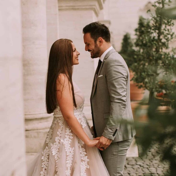 A couple wearing formal clothes, looking and smiling at each other fondly: Wedding anniversary wishes for husband