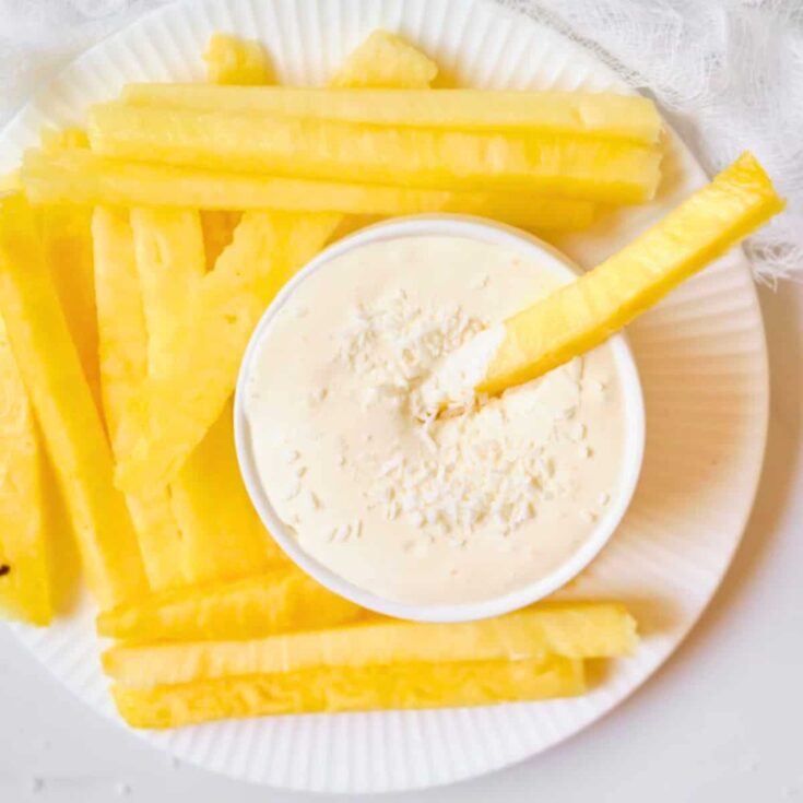 Pina colada fruit dip with sliced pineapples on the side