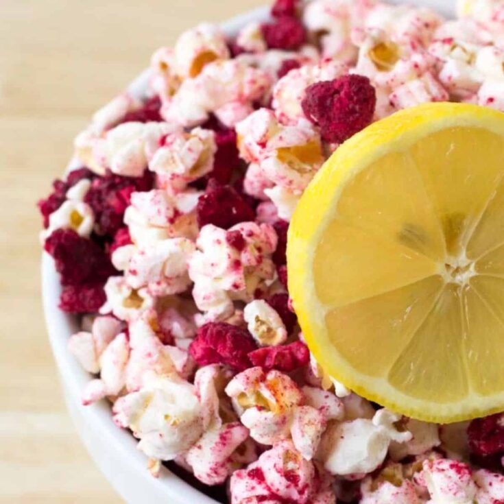 Raspberry lemonade popcorn topped with a sliced lemon