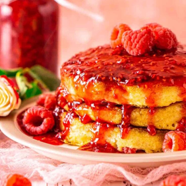 Raspberry pancakes with raspberry syrup on a plate