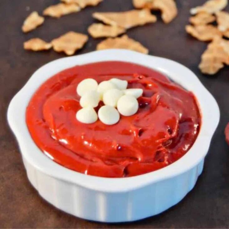 A bowl of red velvet dip topped with white chocolate chips