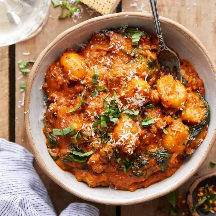 Sausage gnocchi with creamy tomato sauce and spinach in a bowl