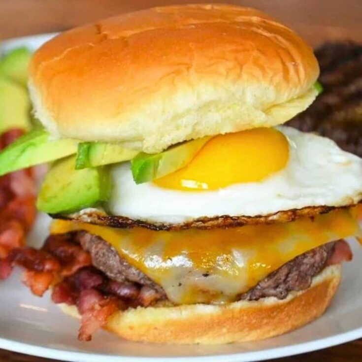 A plate of brunch burger with bacon and fried egg