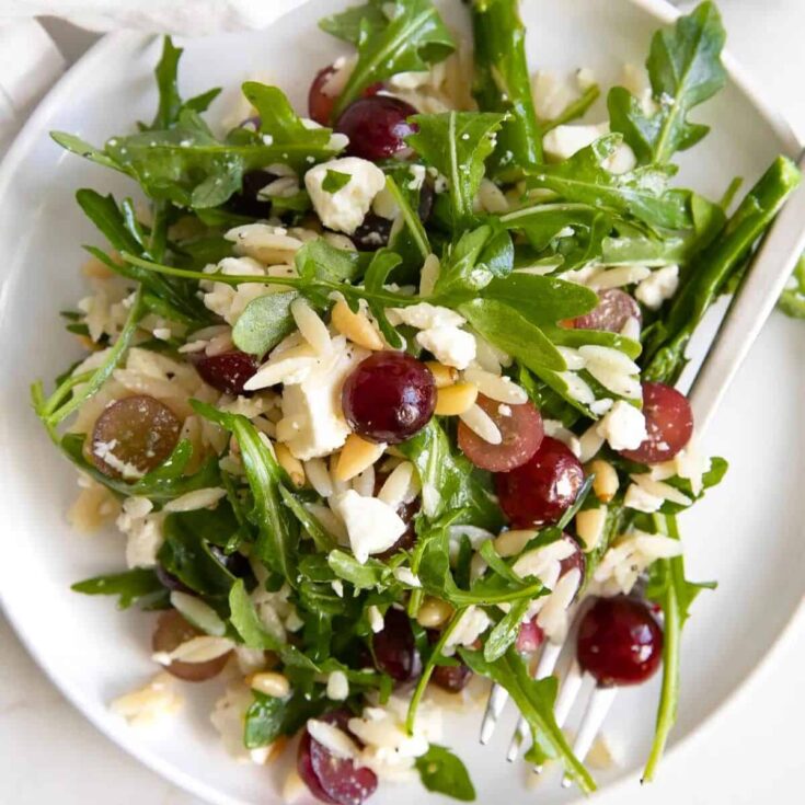 Orzo arugula salad with feta and grapes on a plate