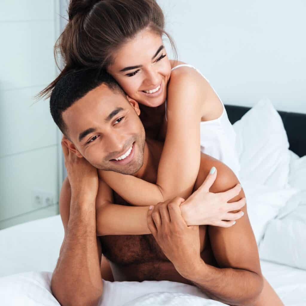 A happy couple snuggling in bed