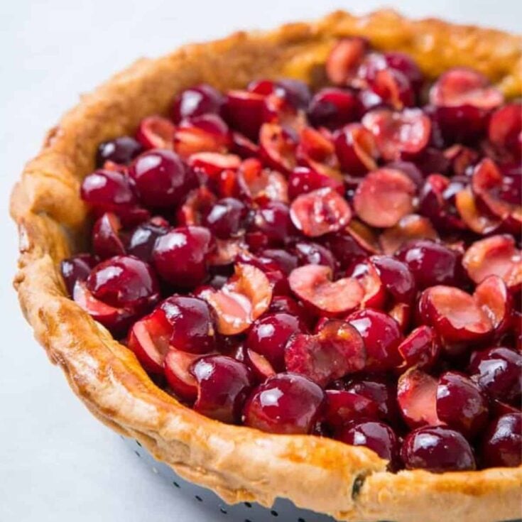 Cherry crumble pie topped with sliced cherries