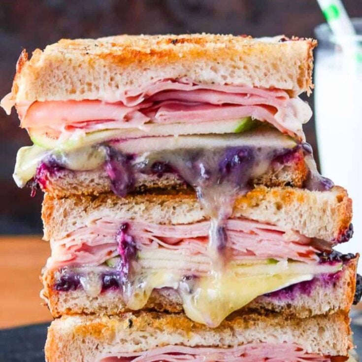 A stack of ham and brie grilled cheese sandwich