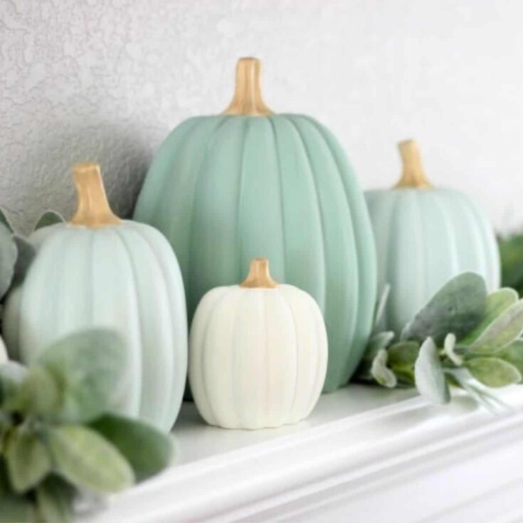 four painted pumpkins in beautiful shades of sage green and cream