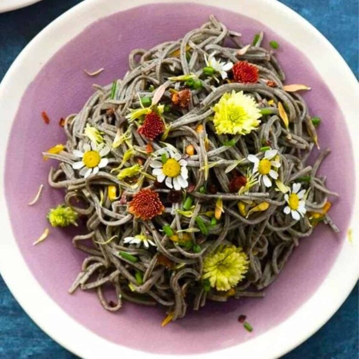 Witch hair pasta topped with little flowers made after reading these Halloween dinner ideas