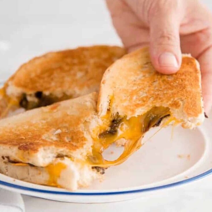 A person pulling a grilled cheese and chocolate sandwich