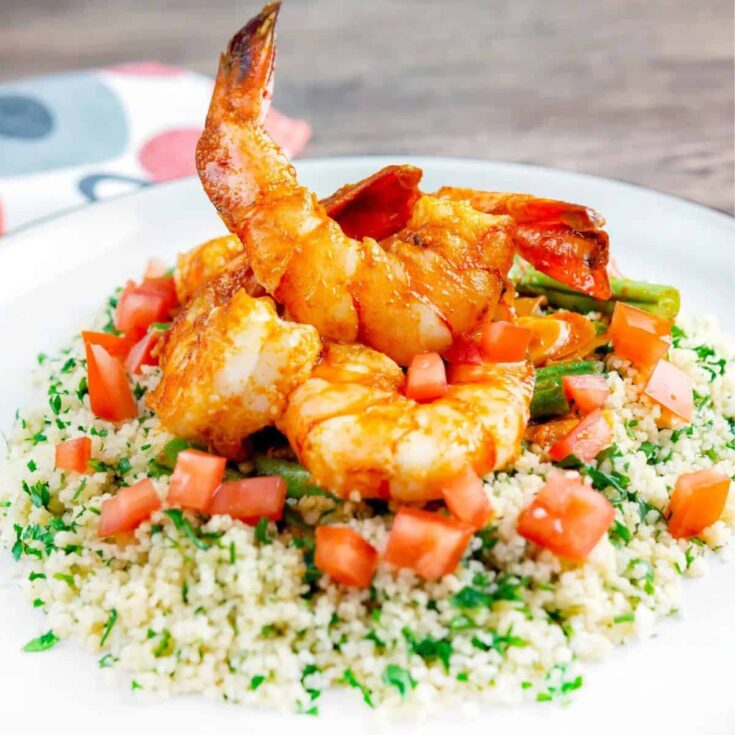 A plate of Harissa garlic prawns with couscous