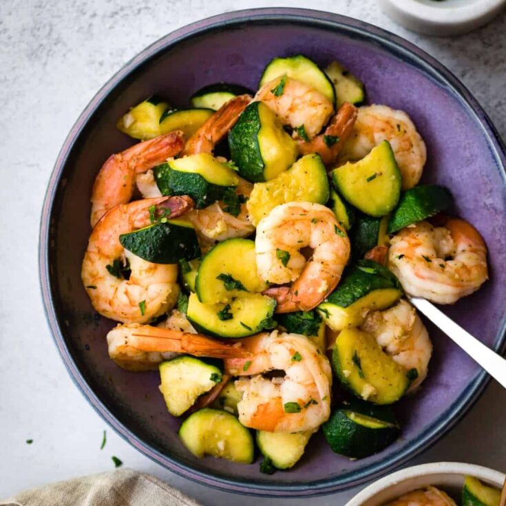 A bowl of sauteed shrimp with zucchini