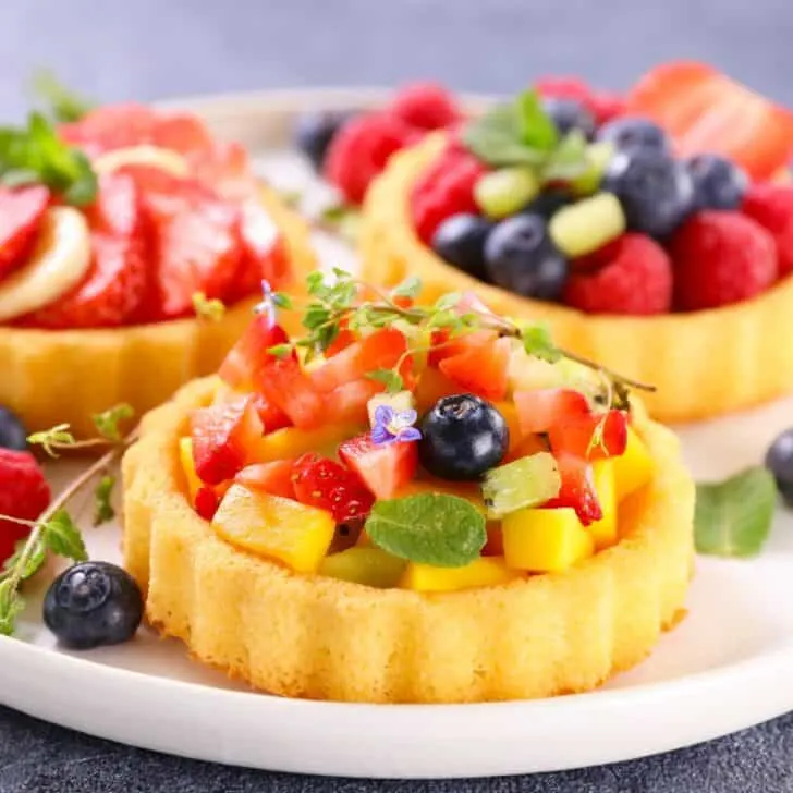 Fruit tart topped with chopped strawberries, pineapples, blueberries and more, made after reading these sweet summer desserts