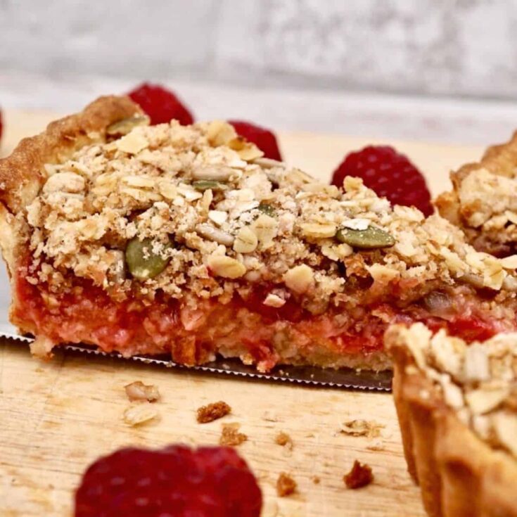 A slice of plum and raspberry crumble tart