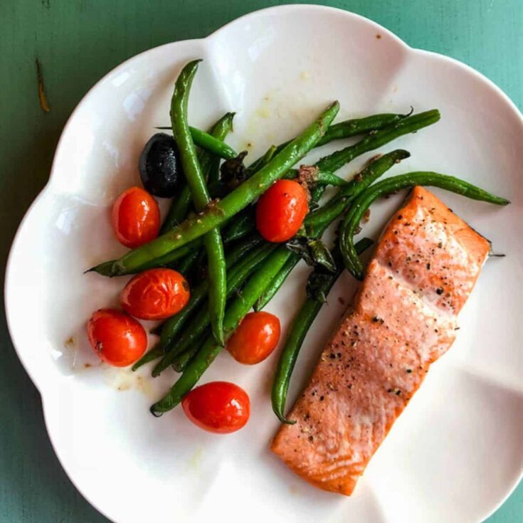 Tray baked salmon and green beans on a plate