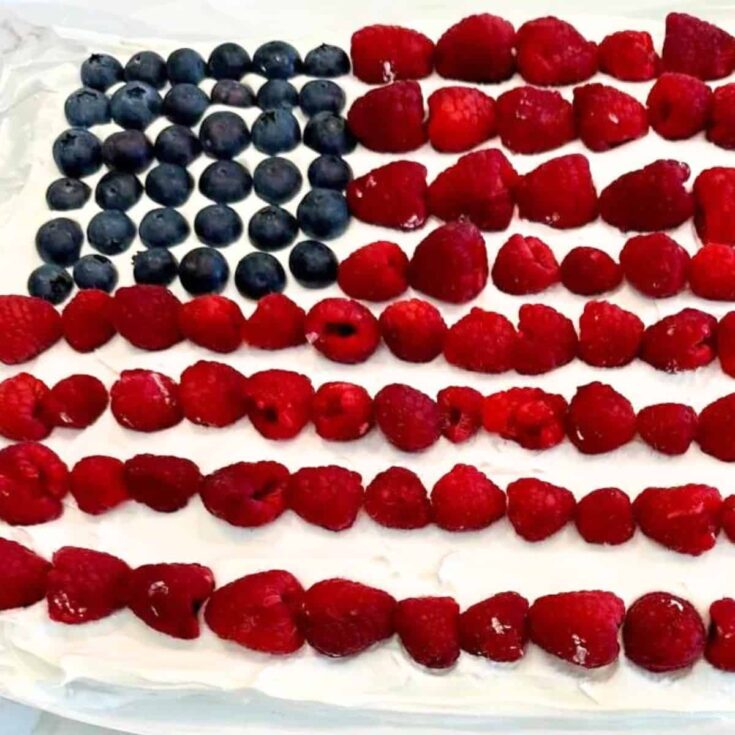 Patriotic ice cream sandwich cake topped with blueberries and strawberries