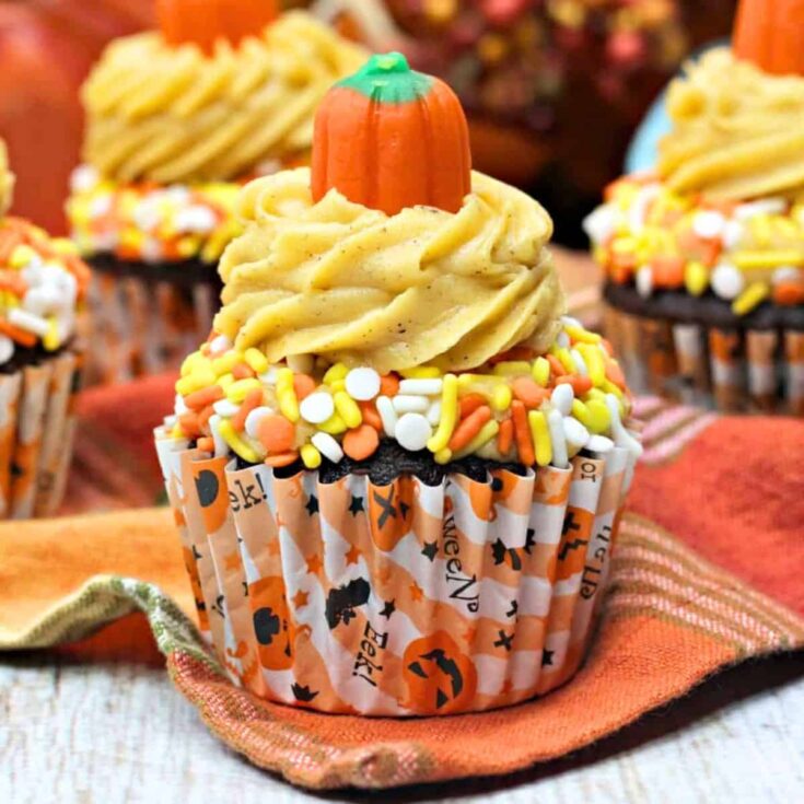 Chocolate coffee mocha topped with sprinkles, cream, and pumpkin-shaped fondant