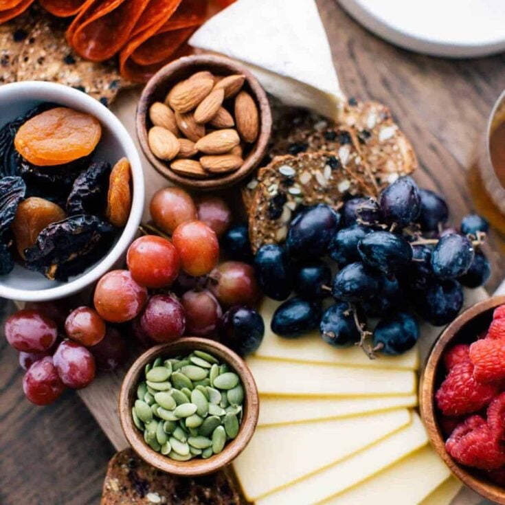 Charcuterie board filled with fruits, nuts, cheese, and meat