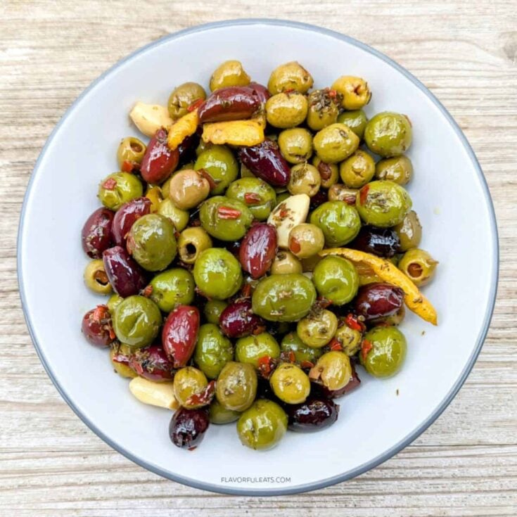 Slow cooker marinated olives served on a plate