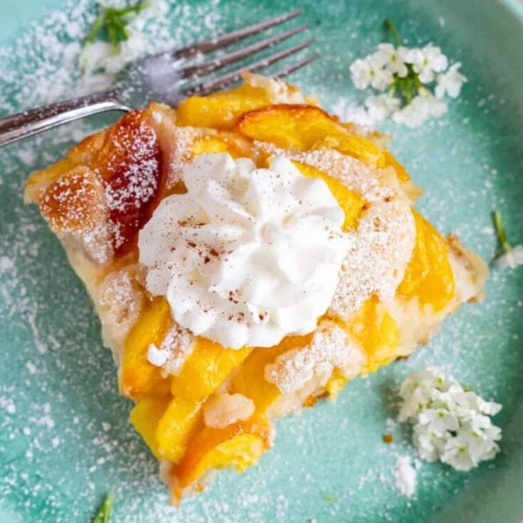 Cream cheese peach cobbler topped with whipped cream