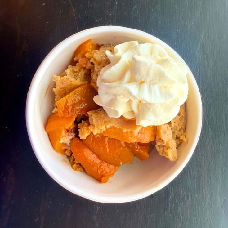 A bowl of slow cooker peach cobbler