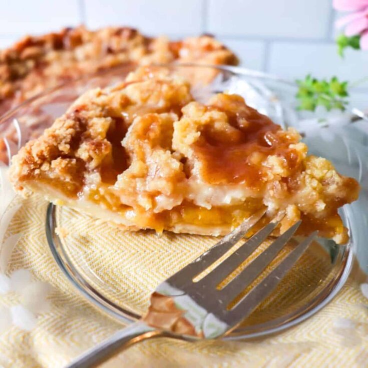 A slice of peach pie with crumb topping