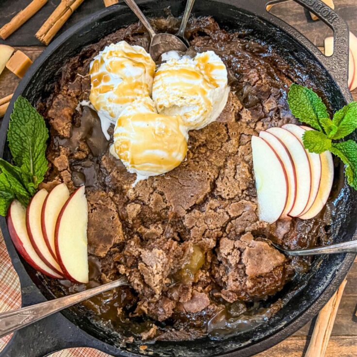 Caramel apple dump cake topped with apple slices and ice cream