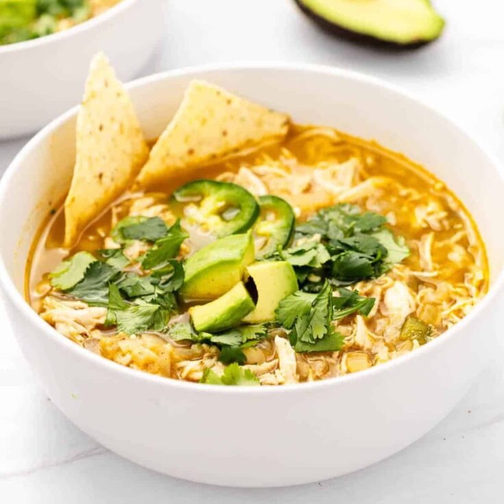 A bowl of creamy white bean chicken chili with nachos on the side