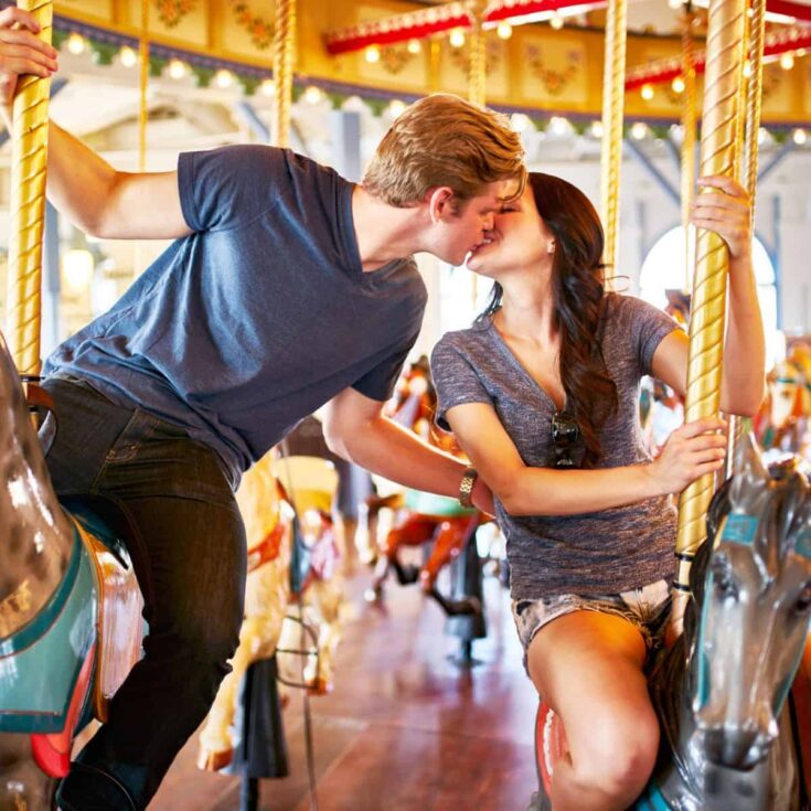 A couple kissing in a carousel ride. Kiss quotes for lovers.