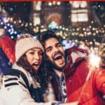 A happy couple celebrating new year together, with the text overlay, new year's resolutions to spice up your love
