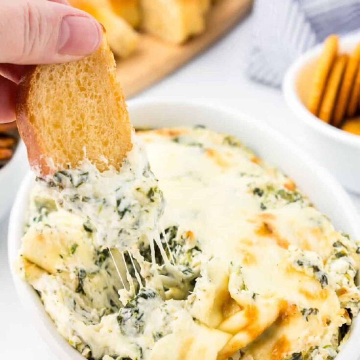 A bread dipped in a hot spinach dip